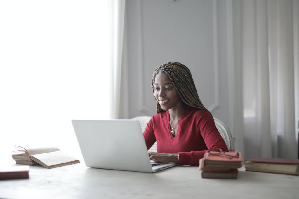 Foto de mulher negra trabalhando no computador em home office