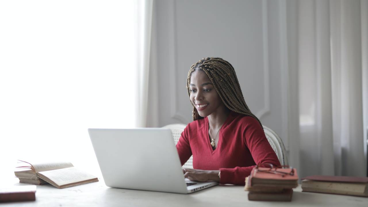 Foto de mulher negra trabalhando no computador em home office