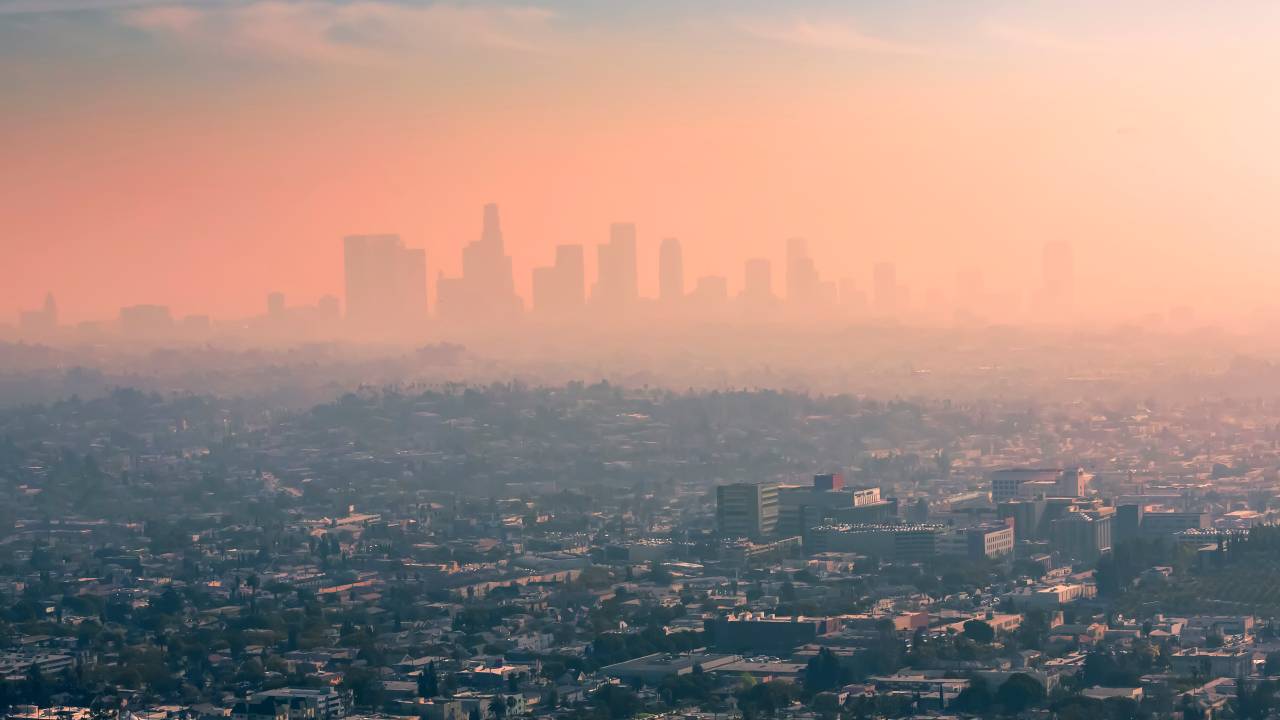 Imagem área da cidade de Los Angeles com um céu cor de rosa por causa da poluição