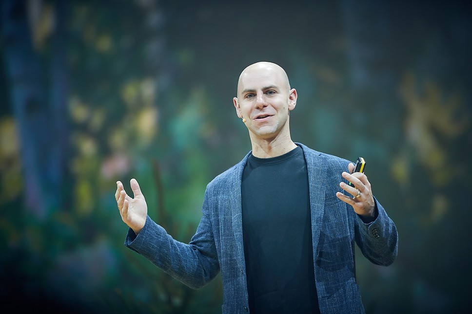 O empresário Adam Grant aparece falando em um evento.