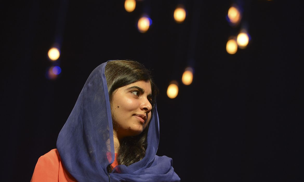 Imagem mostra Malala Yousafzai uma mulher jovem paquistanesa de cabelos escuros e véu azul na cabeça.