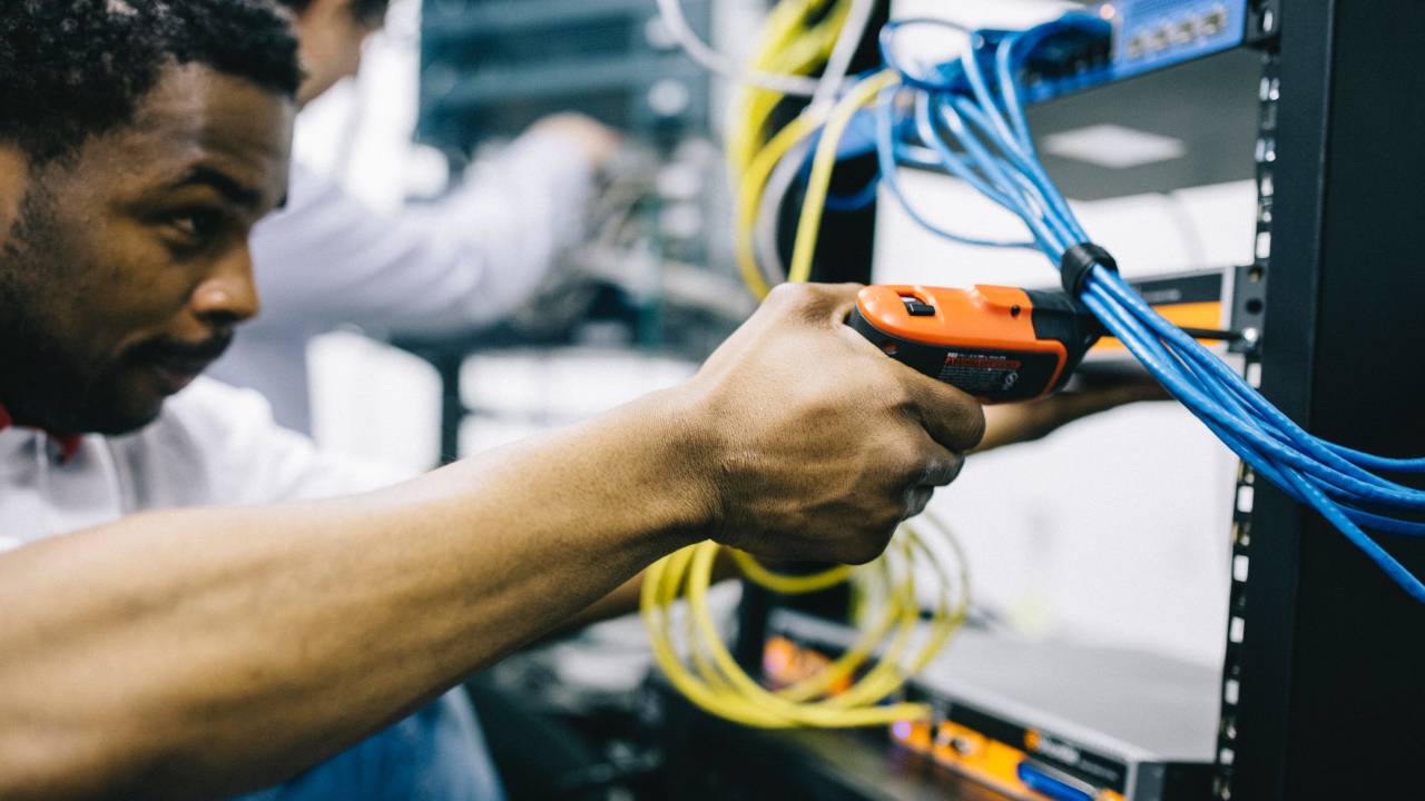 Pessoa segura um equipamento para consertar fios elétricos