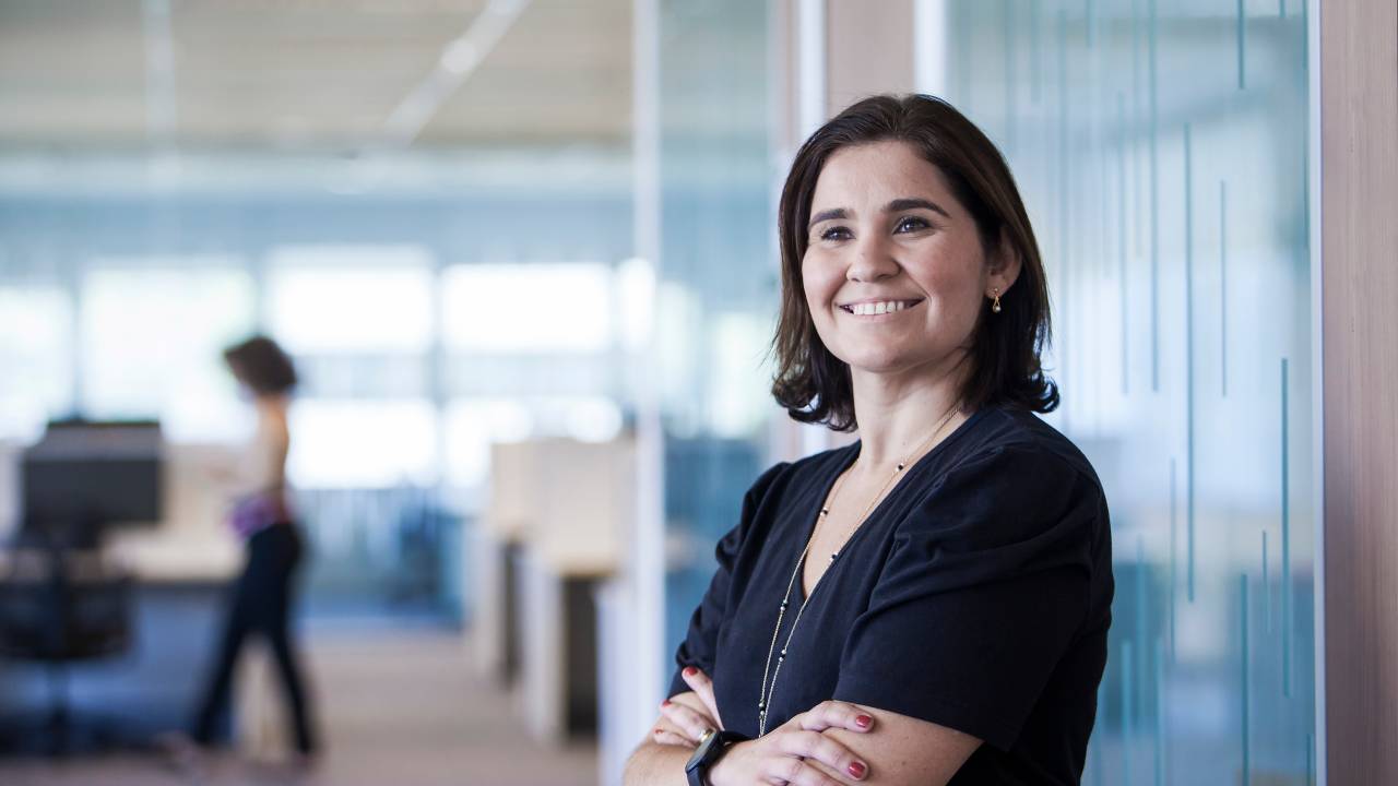 Fernanda Saraiva, diretora de recursos humanos da SAP Brasil, posa sorrido, de braços cruzados, vestida de preto