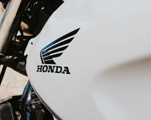 Imagem mostra uma moto com a lataria branca. Sobre a lataria, está o símbolo da Honda