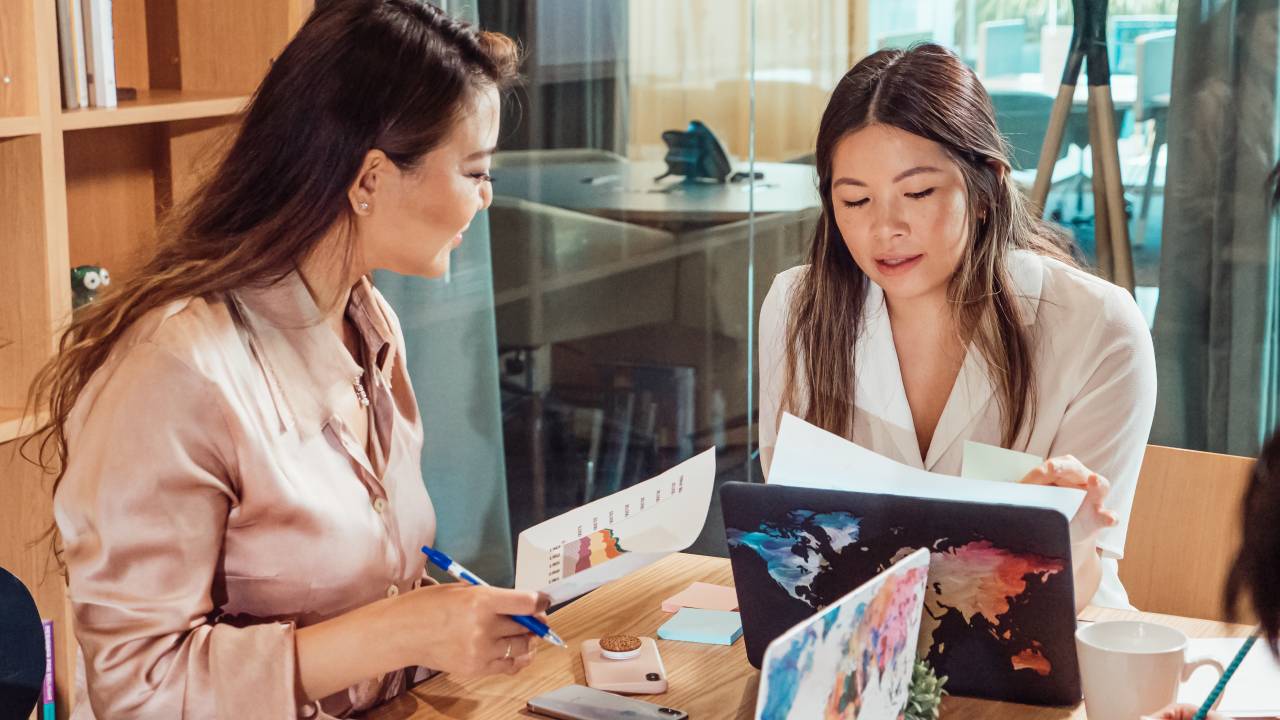 Duas mulheres conversam em uma sala de reuniões