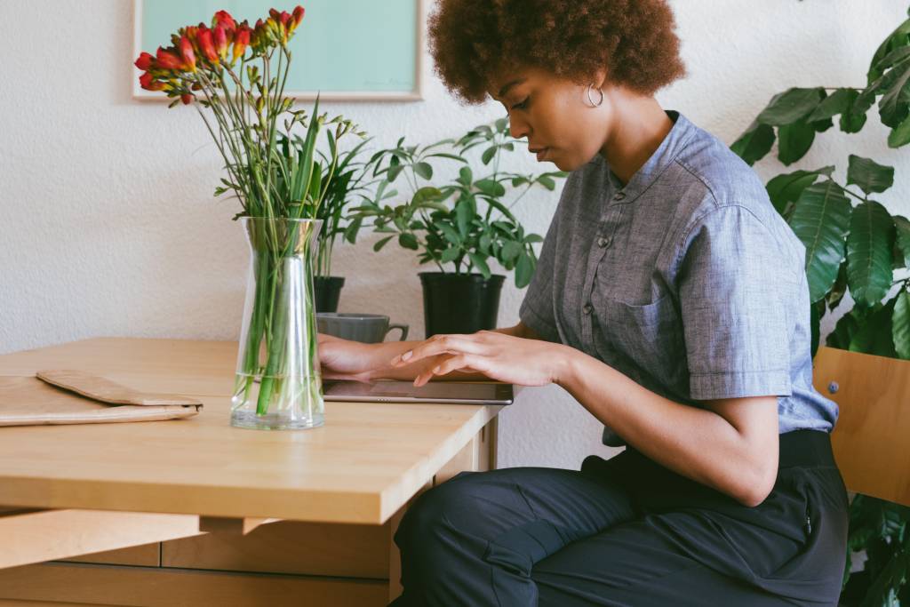 Mulher negra trabalha em home office usando um tablet