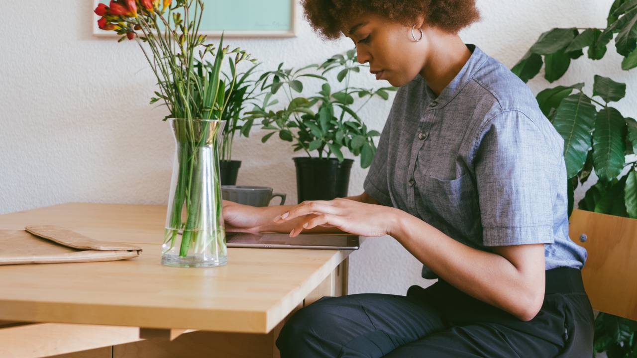 Mulher negra trabalha em home office usando um tablet