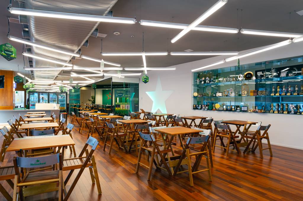 Um ambiente interno da Heineken tem mesas de bar espalhadas