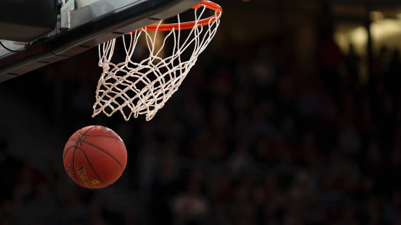 Imagem mostra uma bola de basquete em movimento passando pela cesta