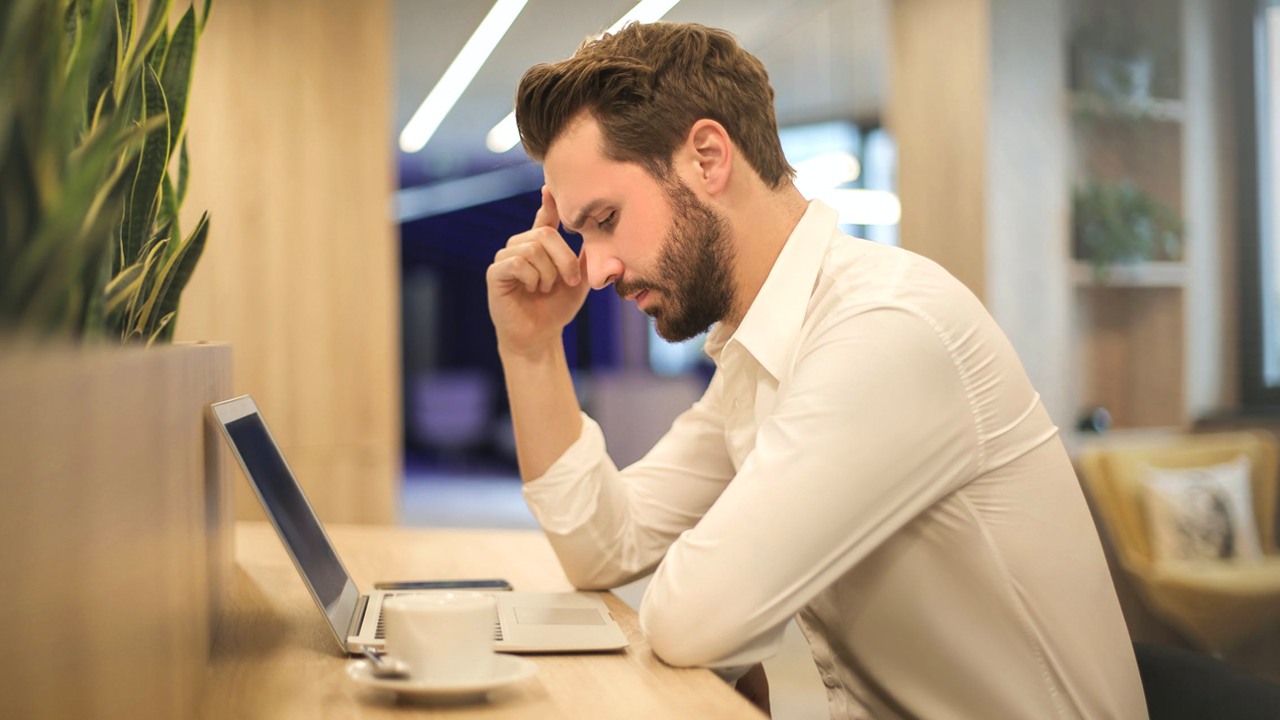 Homem olha apreensivo para o notebook