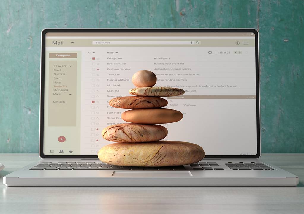 Conceito de pedras equilibradas sobrepostas em um laptop.