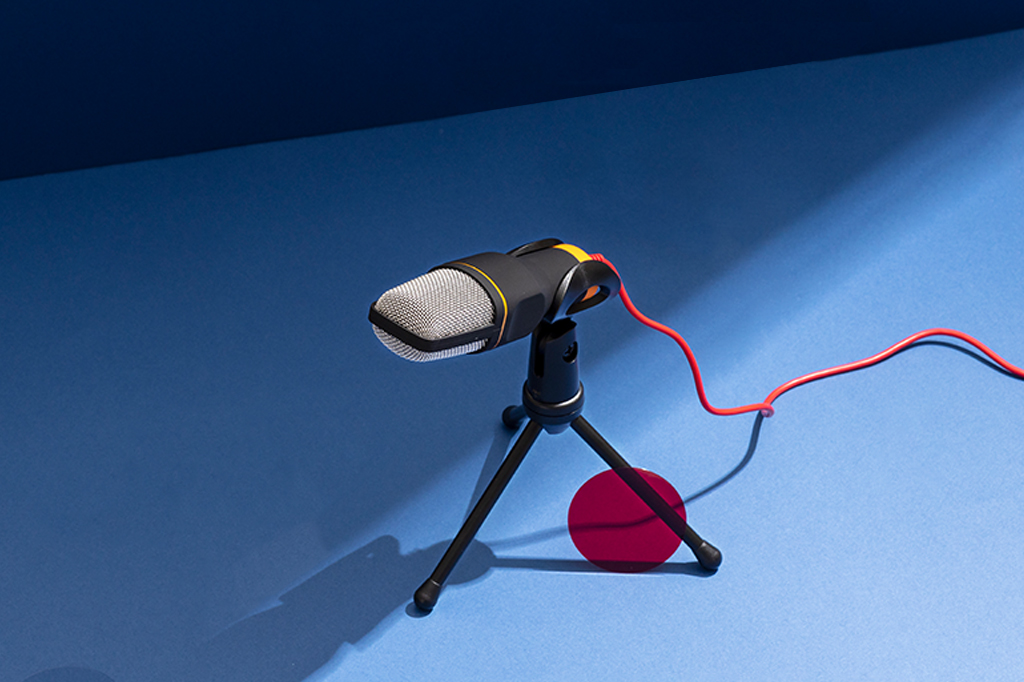 Microfone posto sobre uma mesa de cor auzl.