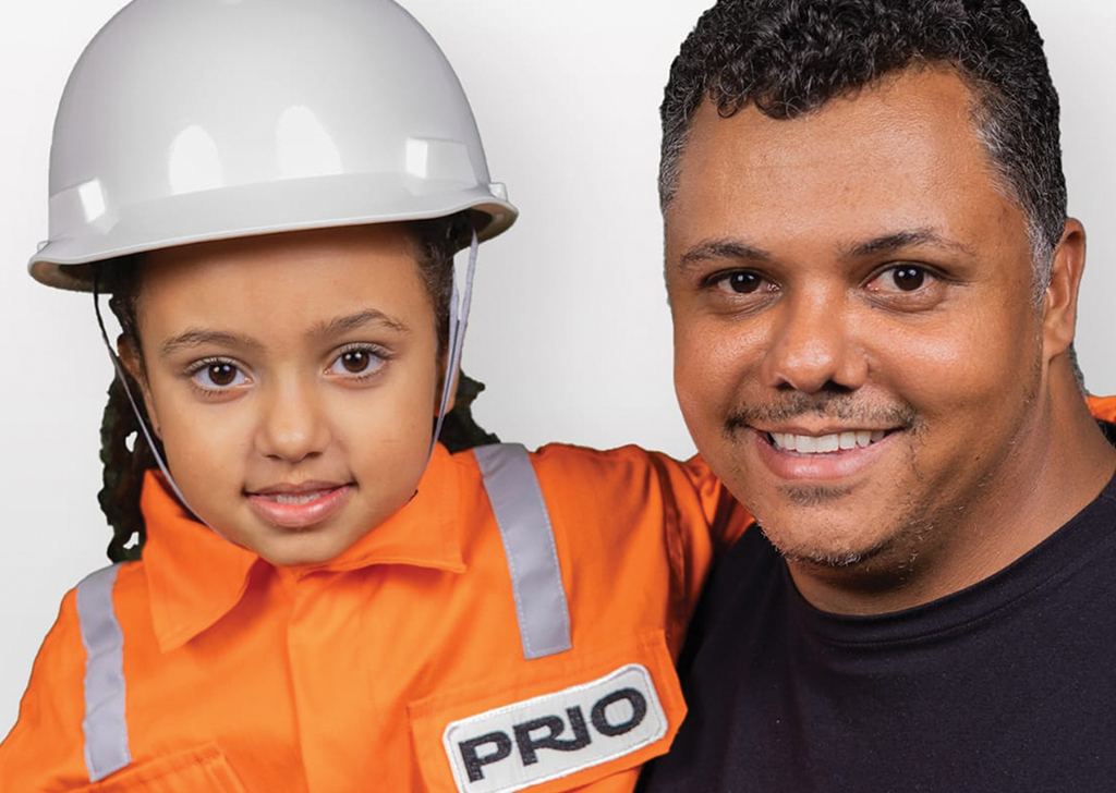 Uma criança com um capacete de proteção ao lado de um homem.