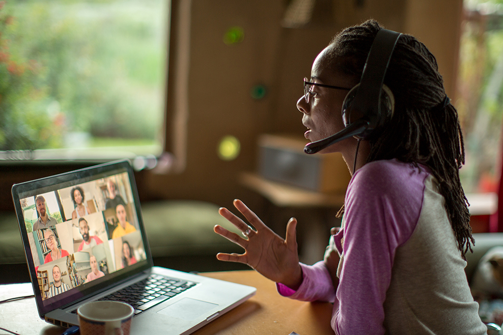 Fotografia de uma mulher participando de uma reunião online de trabalho.