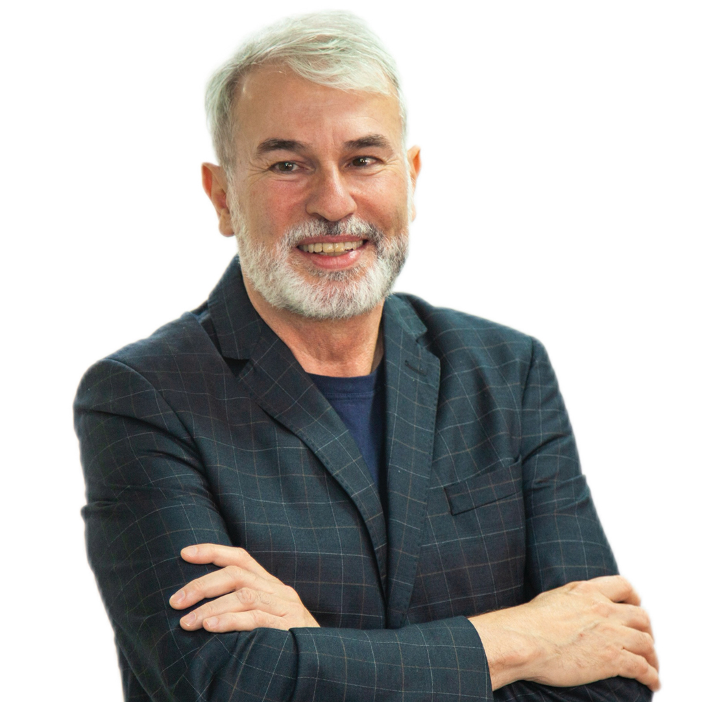 VCRH_98_A_Volta_5 Imagem de um homem sorrindo, de cabelos e barba branca, vestindo um terno preto.