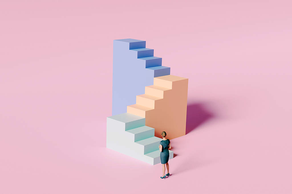 Uma mulher diante de blocos de escadas grandes e altos em um fundo cor de rosa.