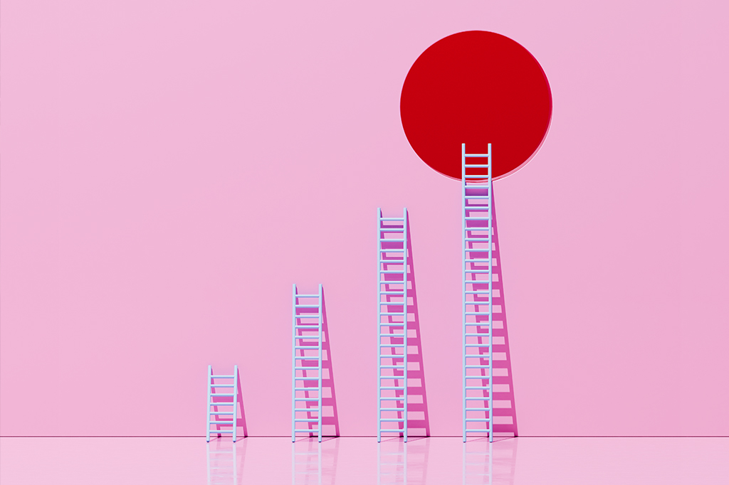 Escadas de tamanhos crescentes apoiadas em uma parede cor de rosa.